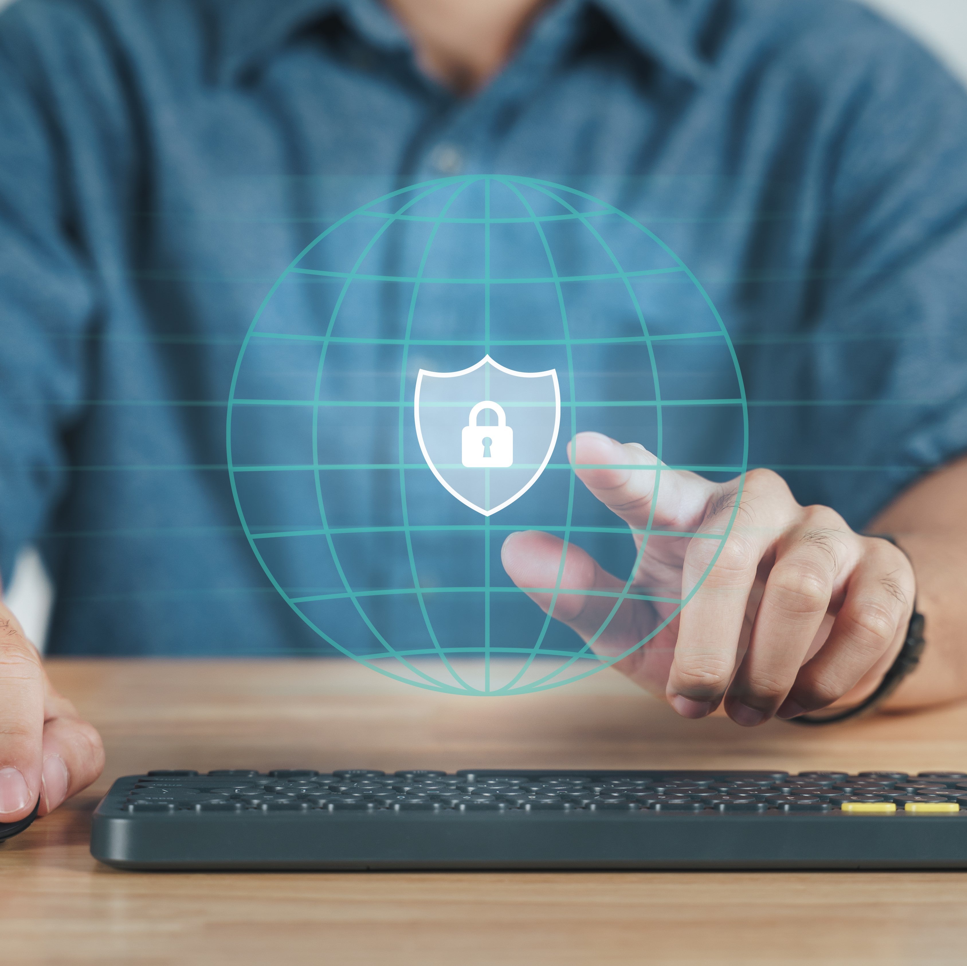 Young man hand touching on virtual Screen Padlock Icon. Black keyboard below hand on desk.