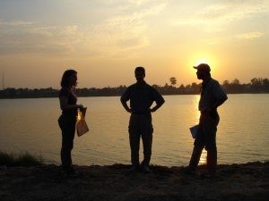 group silhouetted by sunset