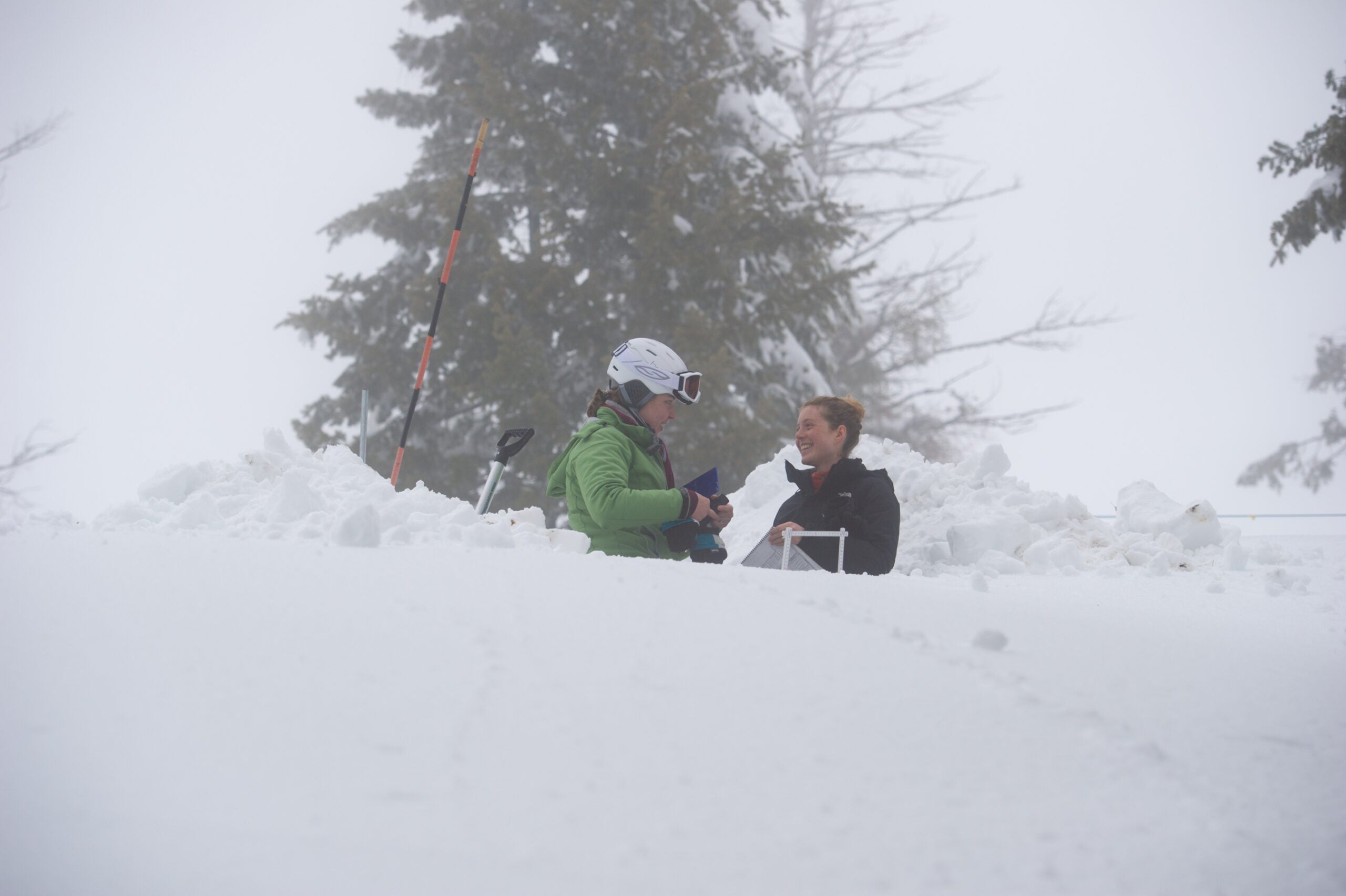 Two people talking in the distance surrounded by snow