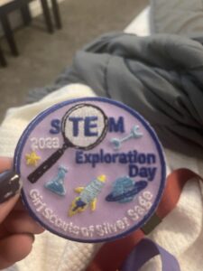 A girl scout patch with STEM exploration day embroidery. 