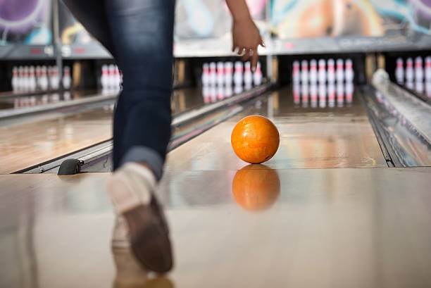 Woman throwing a bowling ball down the lane