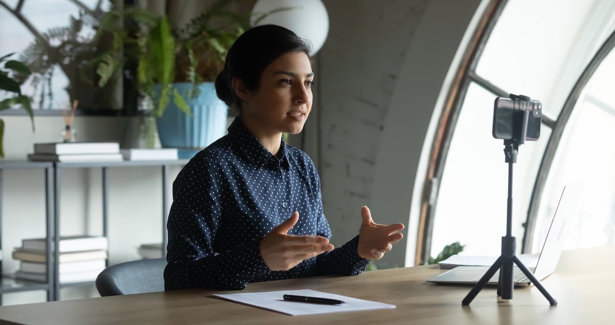 A person takes a meeting on their smartphone.