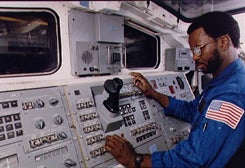 Dr. Ronald McNair at the controls in a space shuttle.