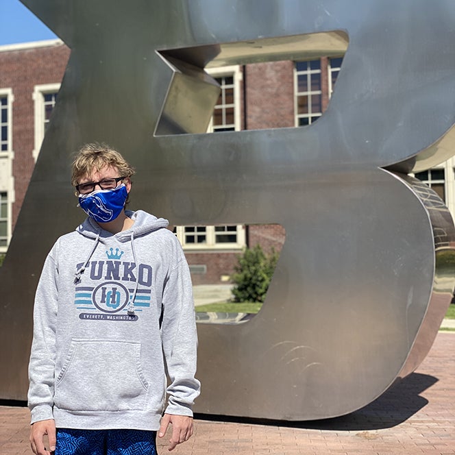 Carter Anderson pictured on campus in front of the B statue