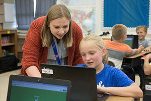 Teacher with student at a computer