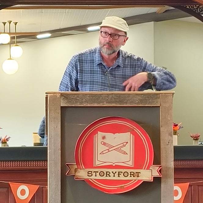 Edvin Subašić Standing in Front of a Podium with a Visible ‘StoryFort’ Sign.