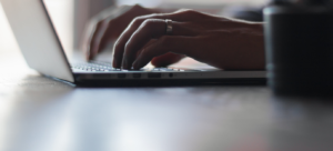 Image of hands typing on a laptop 