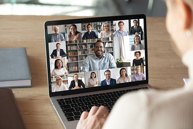 An open laptop with a large teleconferencing meeting on screen