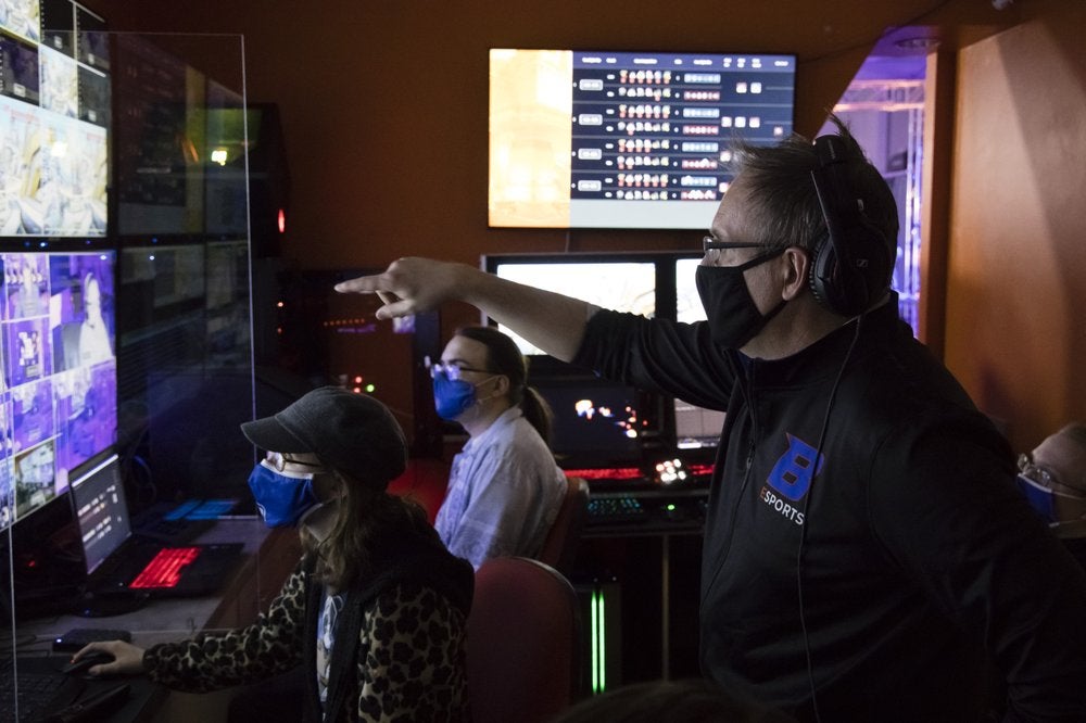 Boise State esports coach Doc Haskell talks to students in the control room during an esports match.