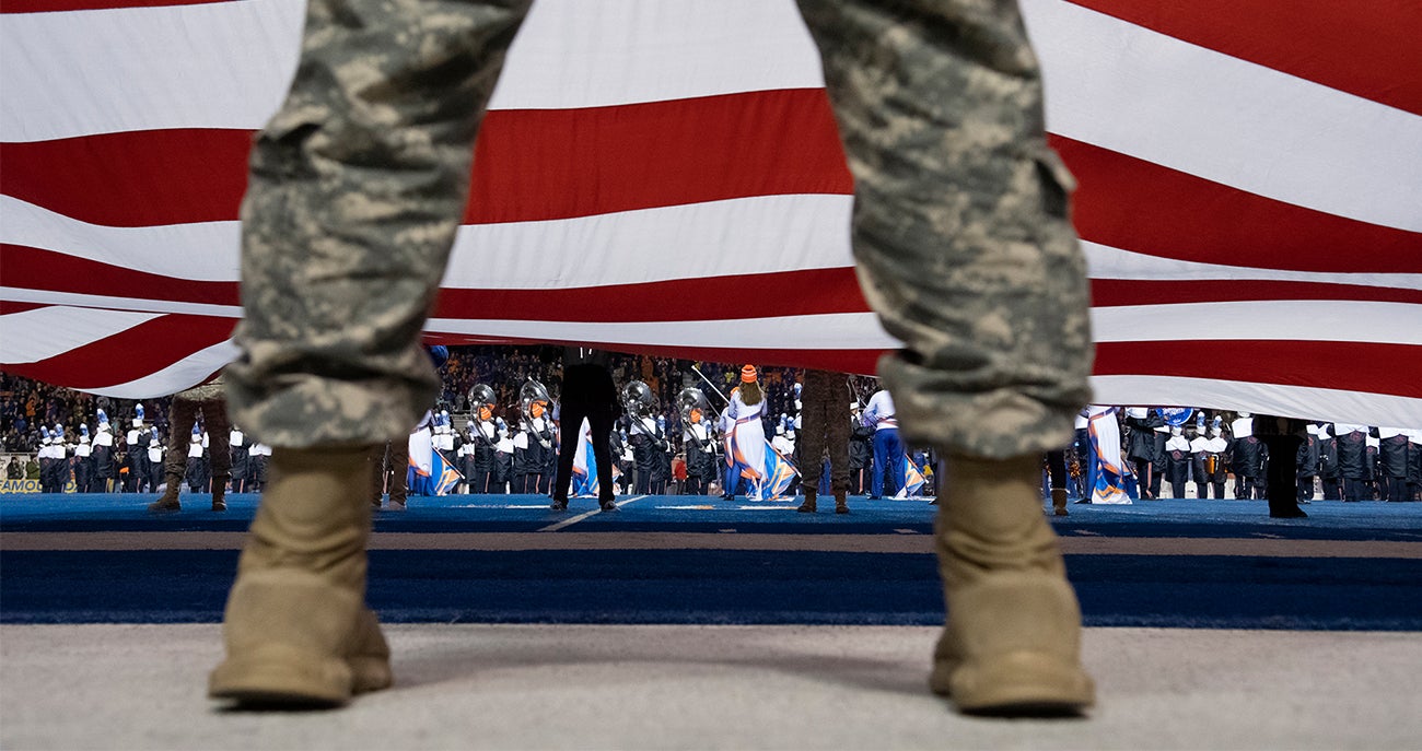 Service member in front of flag