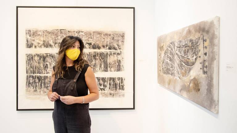 Artist in front of two works