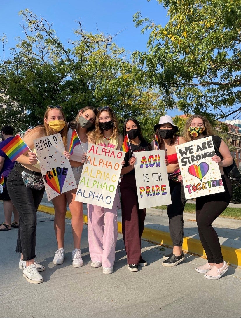 Alpha Omicron Pi members holding AlphaO signs