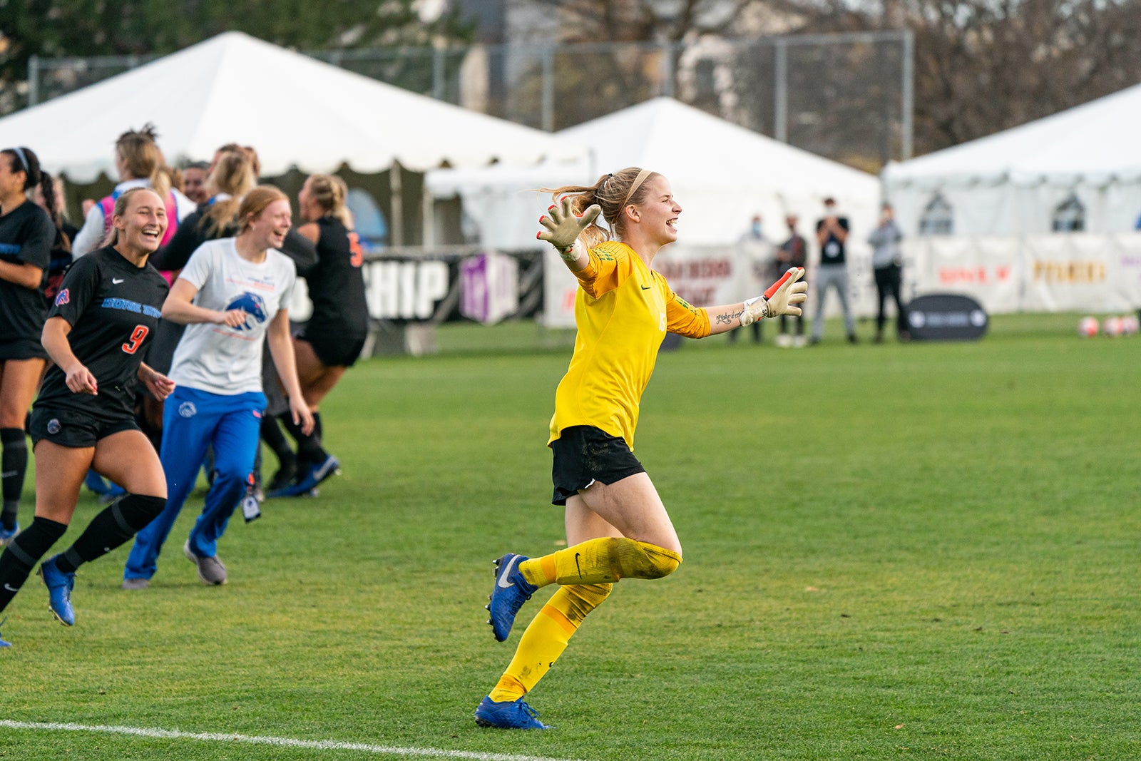 players run onto field smiling and arms open wide
