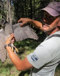 Rob Miller holding a bird in the field