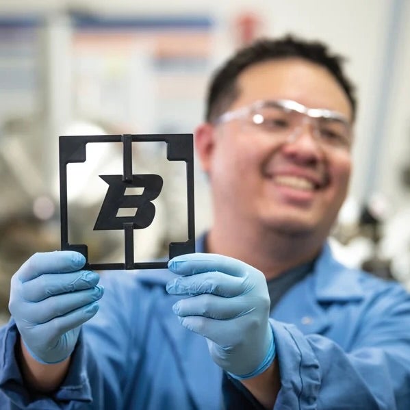 Engineering student holding up a B chip