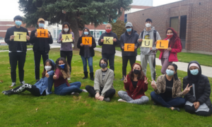Group of students holding a sign that says thankful