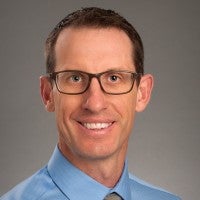 Photo of Travis smiling at the camera