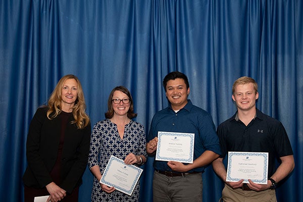 Portrait of grad students holding their award certificates