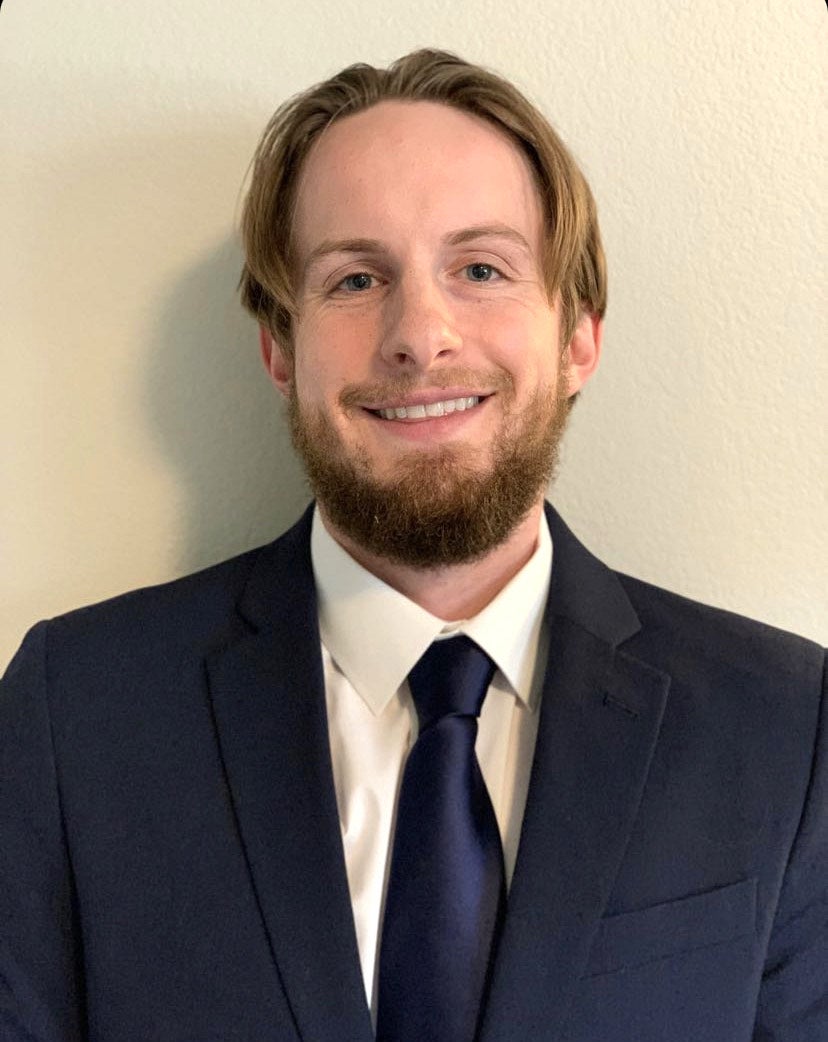 Colton Brodock poses for a photo in a suit and tie.
