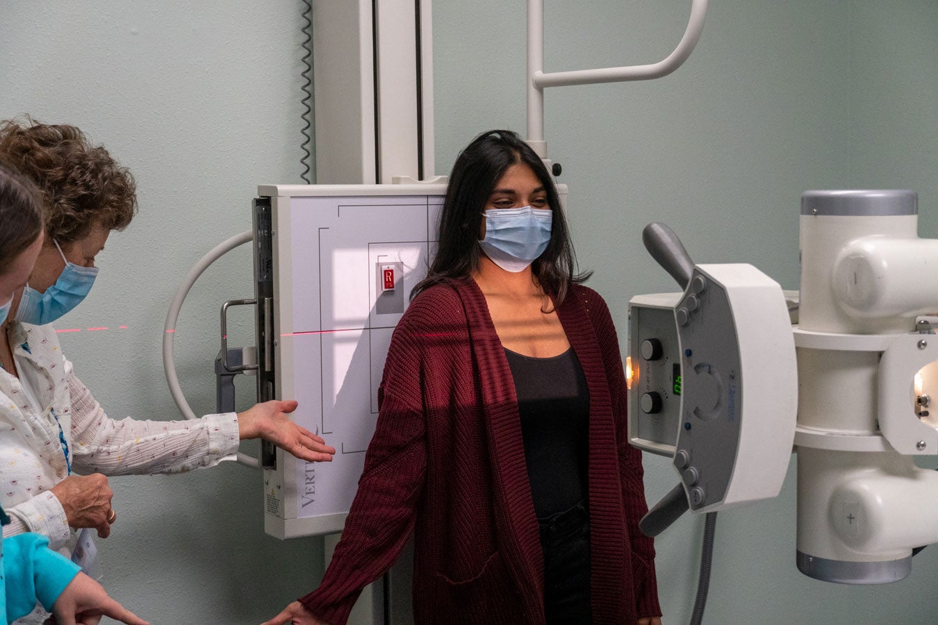 Faculty demonstrates positioning to students, with one acting as the patient ,with a x-ray machine