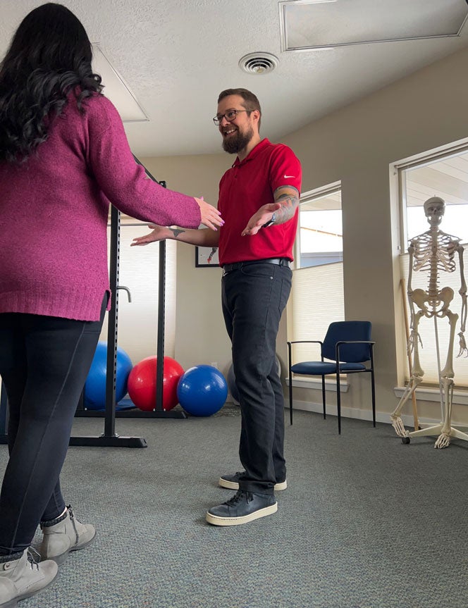 Alumni Austin Adams works with a patient