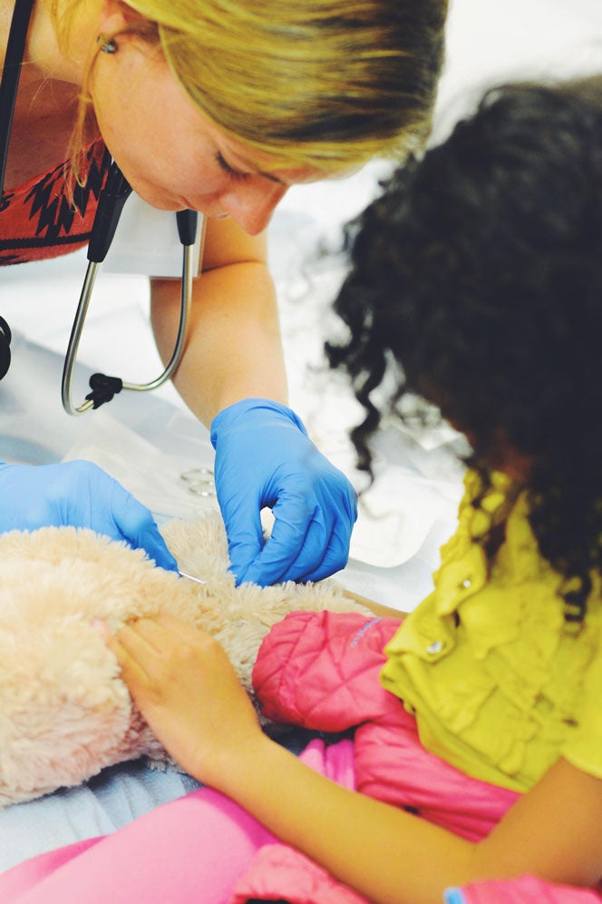 Alumni Kim Dahm performs "surgery" for a child's stuffed toy