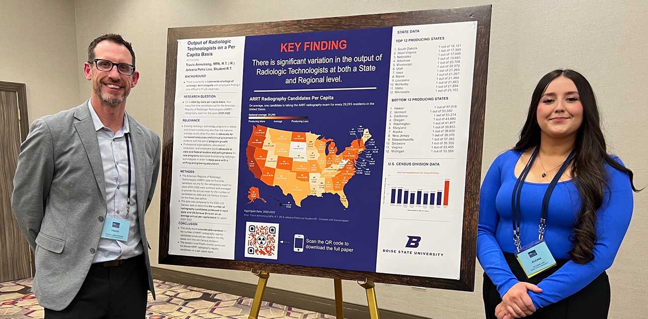 Travis Armstrong and Jeleana Loa pose with their research poster at a conference