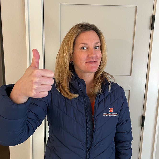 Joelle Powers, new dean of the College of Health Sciences, gives a thumbs up in her college branded jacket.
