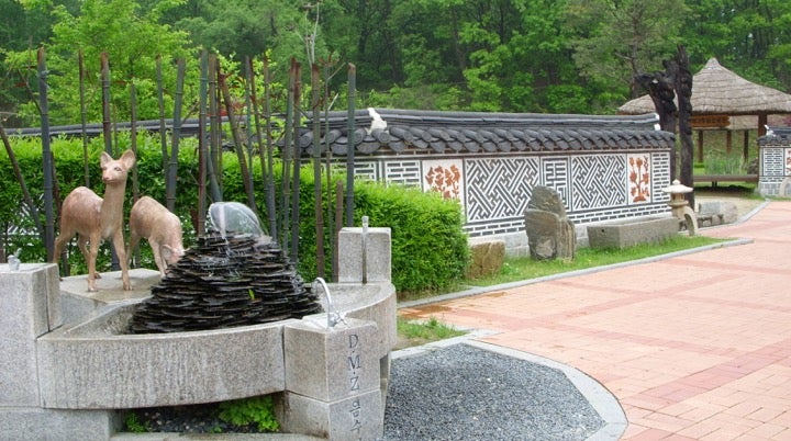 Fountain with deer and monuments surrounded by greenery