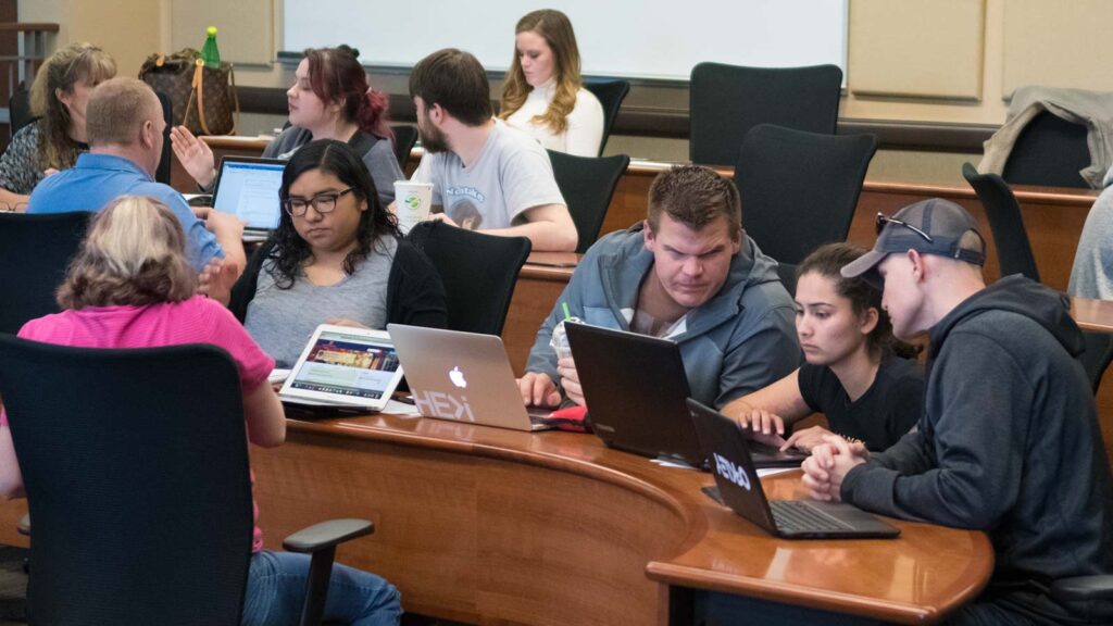 Students working on laptops in a classroom
