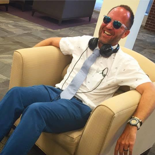 Photo of Dr. Rulon Wood laughing while relaxing on a chair