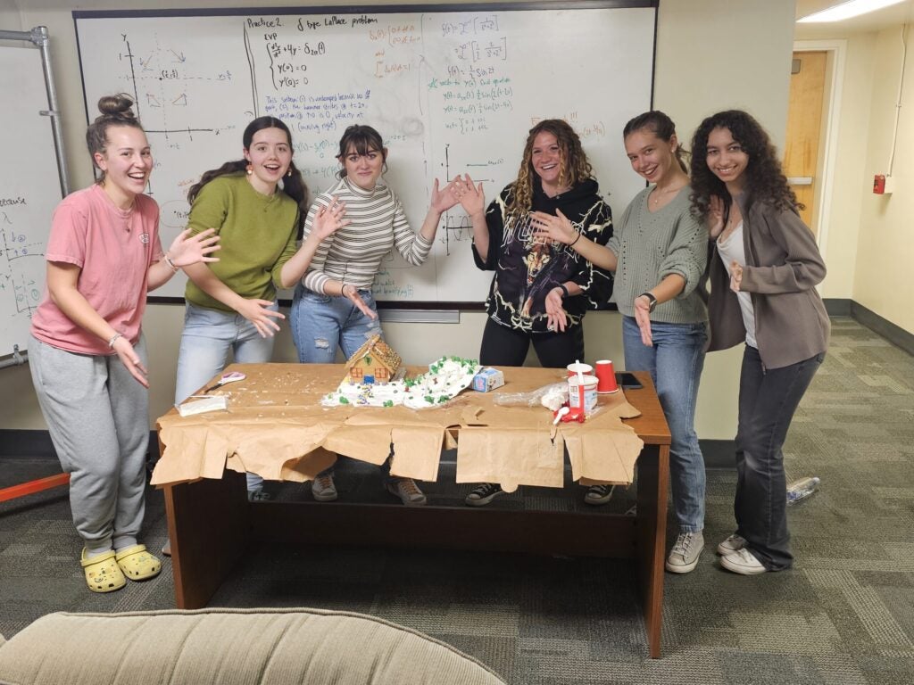 Students building a gingerbread house