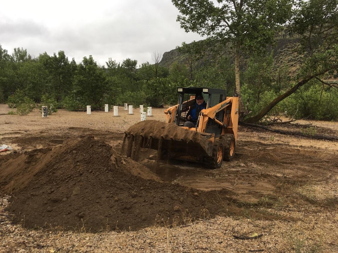a small tractor scoops soil