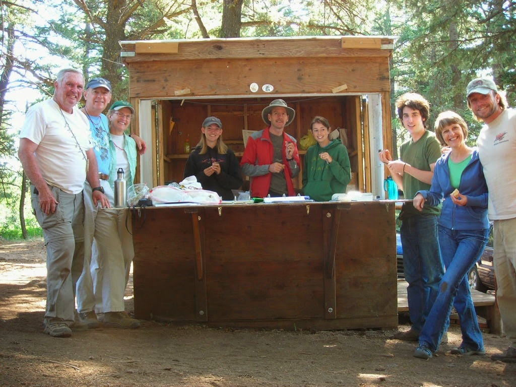 a smiling crew stands around the banding station