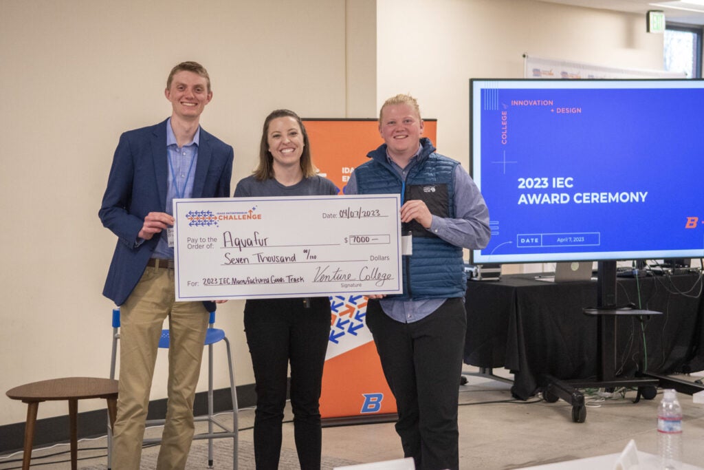 Brayden and Brock Olson, Founders of Aquafur, accepting award check with Cara Van Sant, Venture College Director