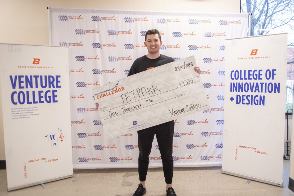 Jaxon Evans, Founder of JETPAKK, posing with his prize award