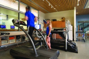 Student observing participant running on treadmill
