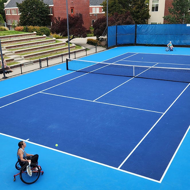Two female players in wheelchairs play in a tennis match at Boise State's Appleton Tennis Center
