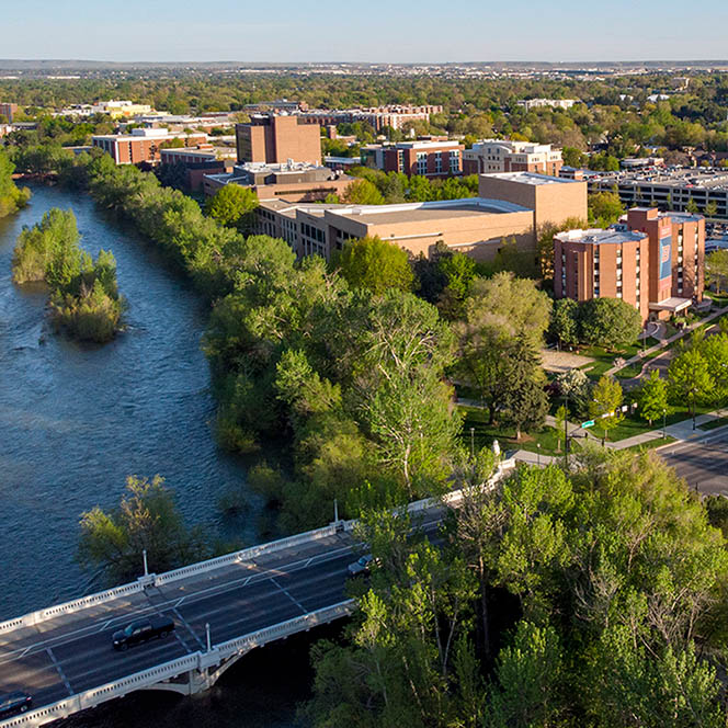 View of campus by river with trees.