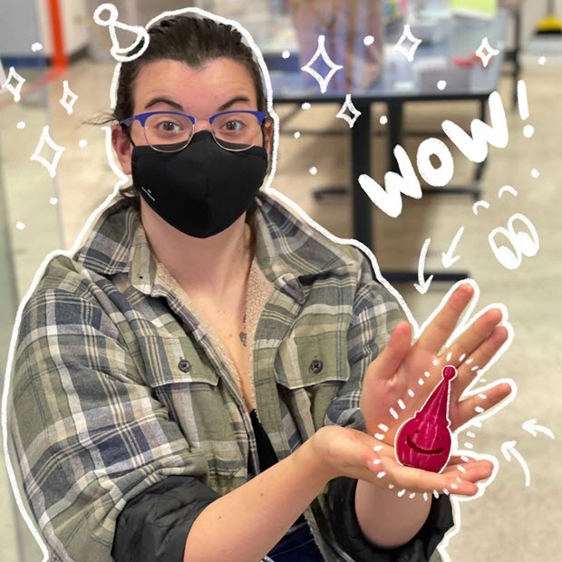 MakerLab student Cali holding a small 3D printed pumpkin