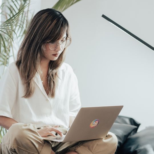 young female looking down at a laptop computer