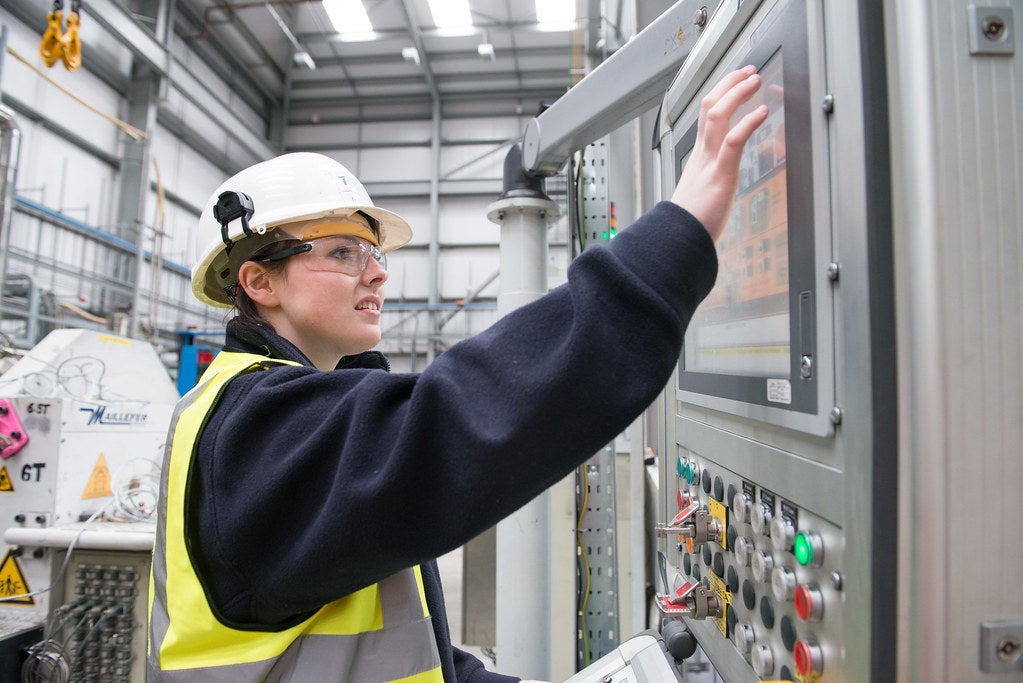 A worker taps on a machine screen