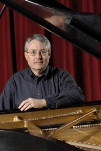 Photo of Mark Hansen sitting at a piano.
