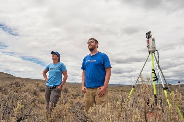 Two people watch a drone