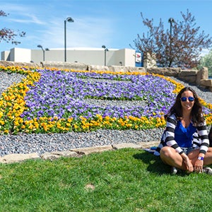 Student in front of B flower arrangement