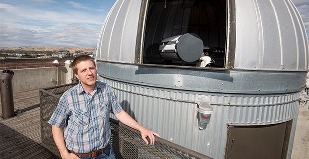 Man stands next to telescope