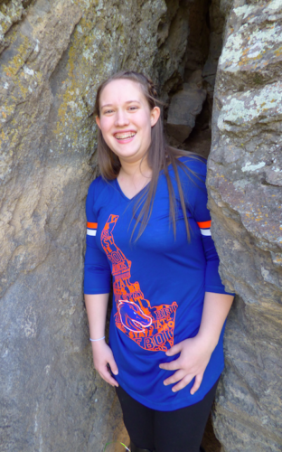 A student beaming between rocks