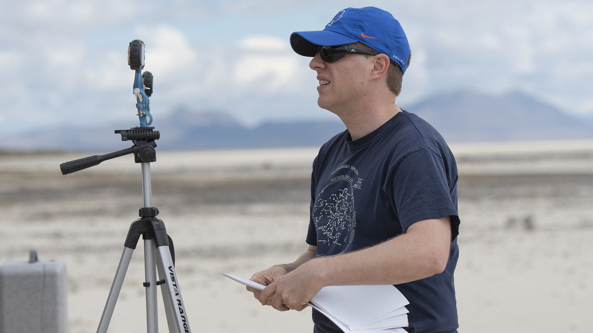 Researcher standing in front of a tripod holding equipment