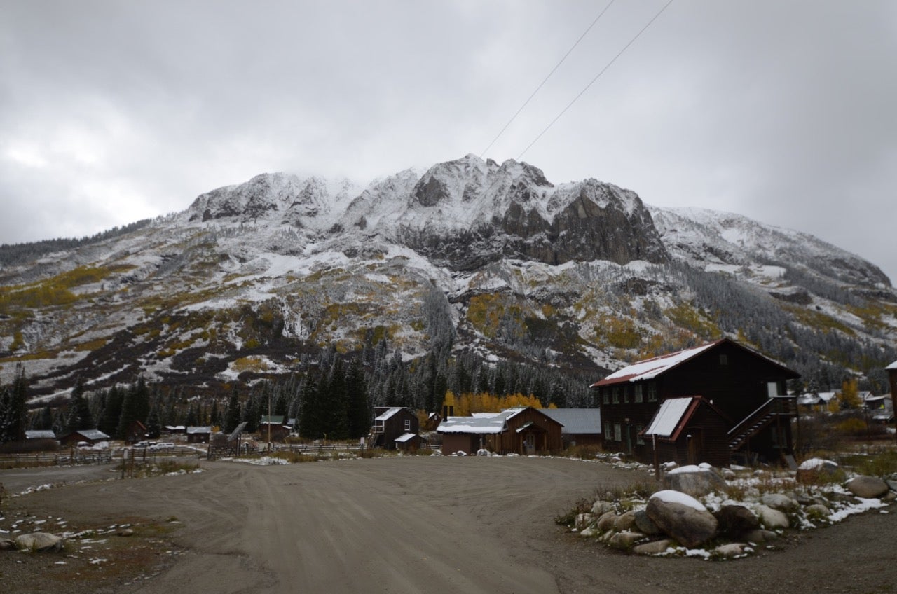 mountain landscape with a few cabins at the base.