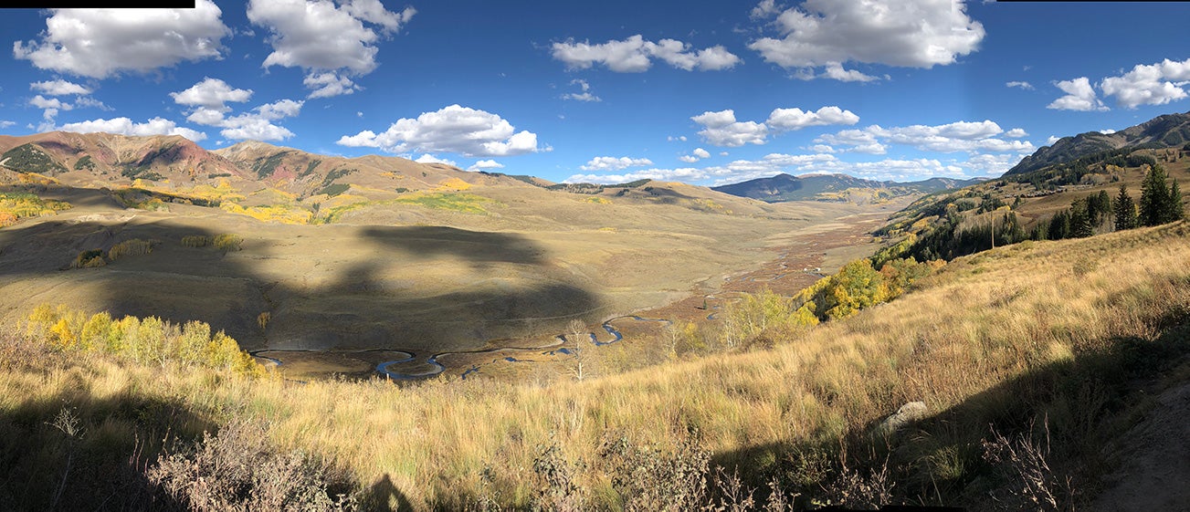 foothills under bright blue sky and clouds